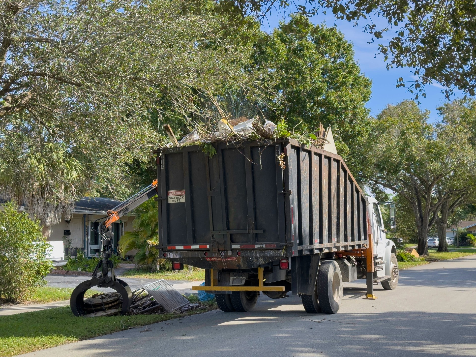 Bulk truck picking up trash in a community street